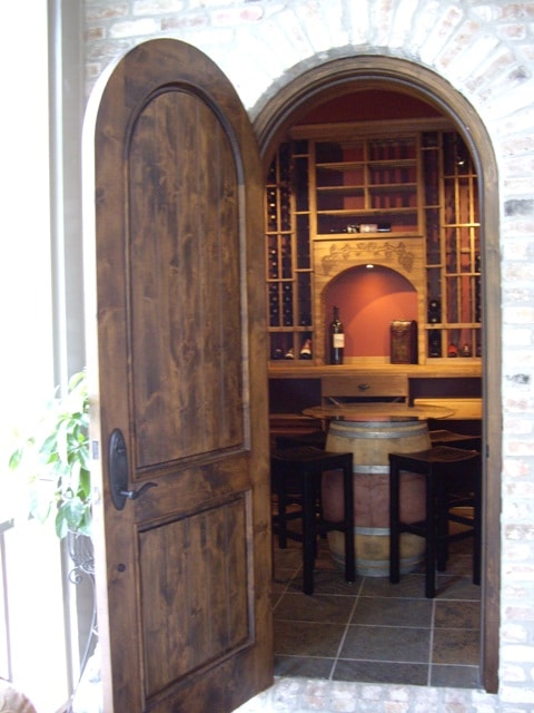 Traditional Custom Wine Cellar Design with Wood Wine Racks and a Wine Barrel Table